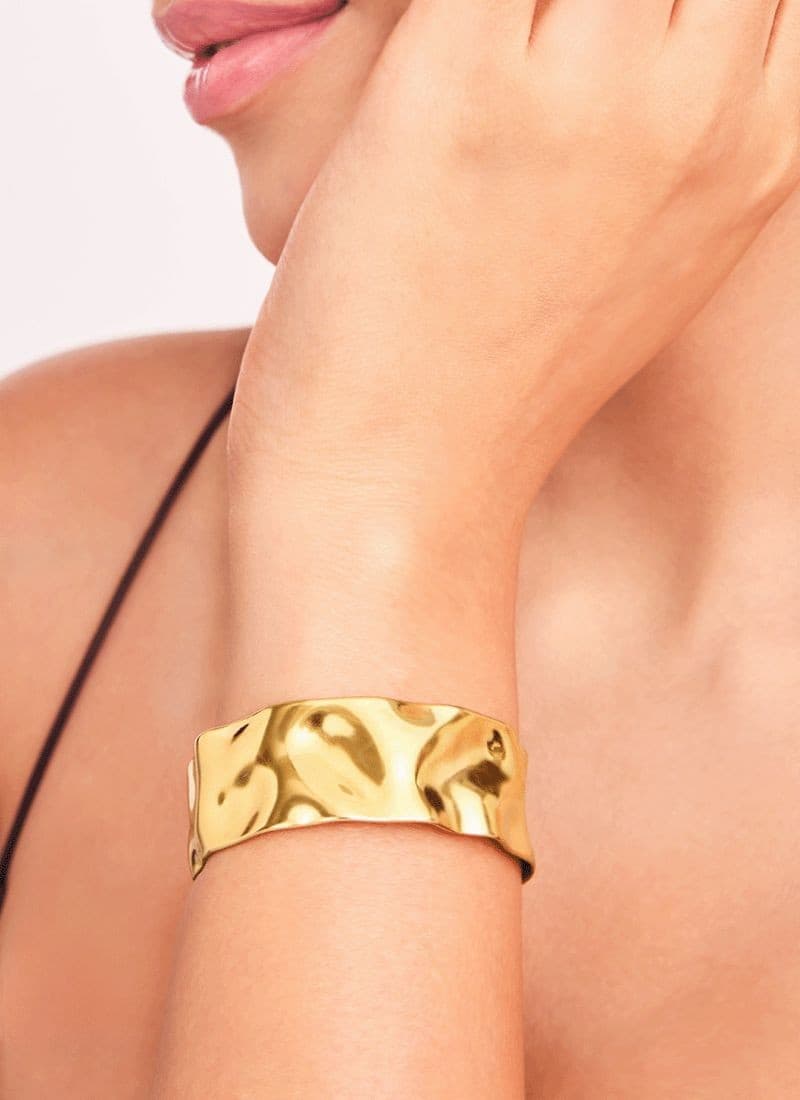 Model wearing 18k gold plated golden wave cuff bracelet by elra