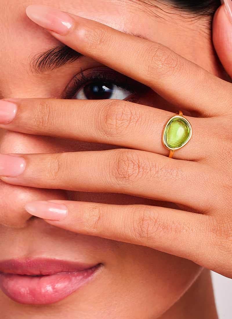 Woman wearing Verdant Glow Ring green stone gold ring